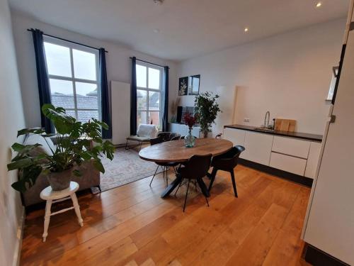a living room with a table and chairs and a kitchen at luxury house between the windmills in old center in Winsum