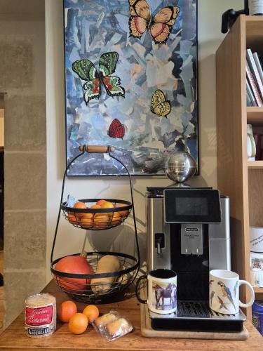 einen Tisch mit Kaffeemaschine und Laptop darauf in der Unterkunft Marcart, sur le sentier du Miosson Saint Benoit in Saint-Benoît