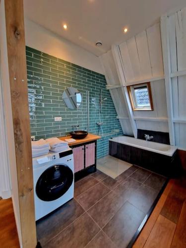 a bathroom with a toilet and a sink and a tub at luxury house between the windmills in old center in Winsum