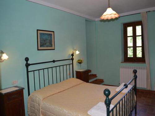 a bedroom with a bed with blue walls and a window at Charming flat with pool surrounded by nature in Asciano