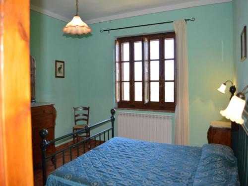 ein Schlafzimmer mit einem Bett und einem Fenster in der Unterkunft Cozy Tuscan countryside escape in Asciano