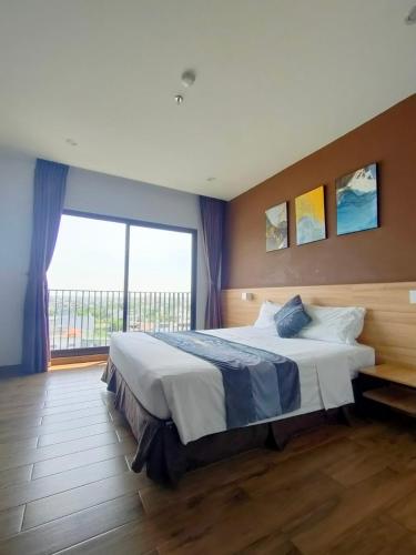 a bedroom with a large bed with a large window at KingSales Hotel in Thanh Hóa