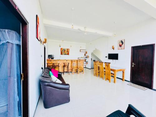 a living room with a couch and a dining room at Reefline villa in Weligama