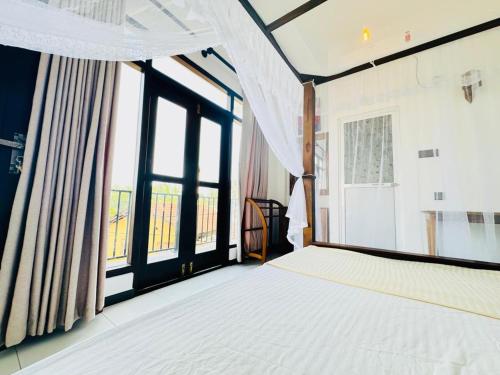 a bedroom with a bed and large windows at Reefline Villa in Weligama