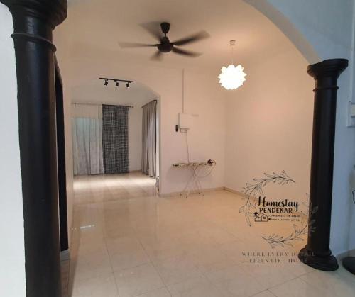 an empty living room with a ceiling fan at Homestay Pendekar Guntong in Kampong Jereneh
