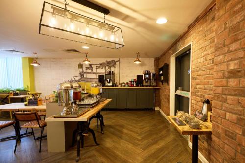 a kitchen with a table and a brick wall at Holiday Inn - the niu, Loom Manchester North by IHG in Manchester