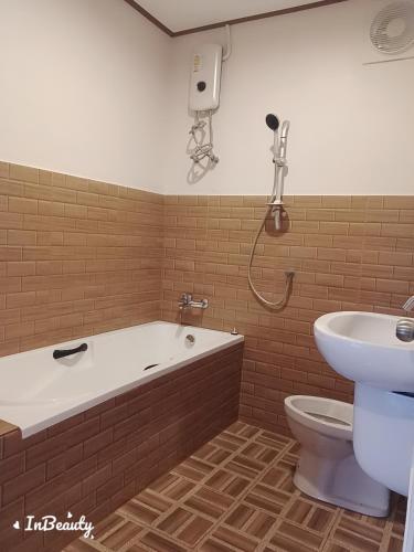 a bathroom with a tub and a toilet and a sink at เฟรนด์แคมป์เขาค้อ in Ban Thung Samo