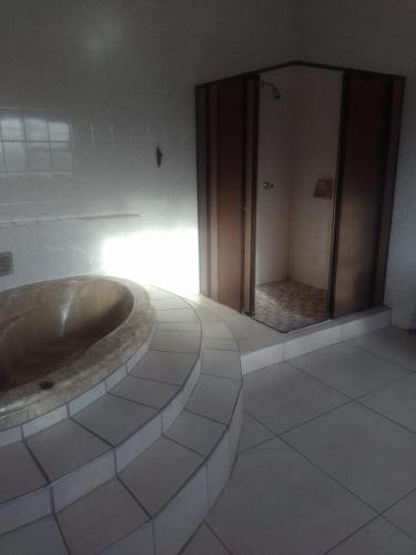 a bathroom with a tub and a large mirror at Tara's Terrace Guest House in King Williamʼs Town
