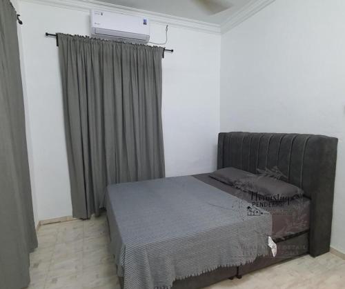 a bedroom with a bed in a room at Homestay Pendekar Guntong in Kampong Jereneh