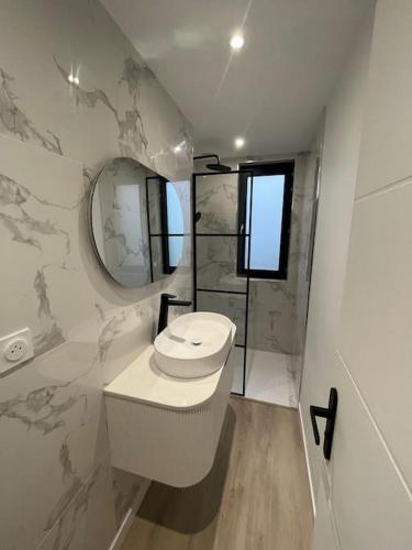 La salle de bains blanche est pourvue de toilettes et d'un miroir. dans l'établissement Luxueux 3 Chambres Tout Confort, à Maubeuge