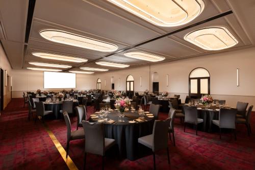 a banquet room with tables and chairs and a screen at Adelaide Marriott Hotel in Adelaide