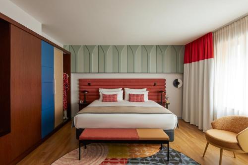 a bedroom with a large bed and a chair at Hotel Indigo Barcelona Plaza Espana by IHG in Barcelona