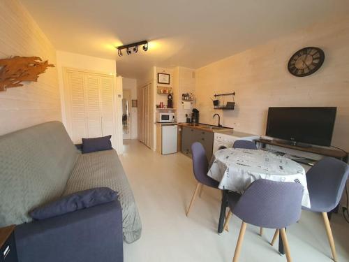 un salon avec un canapé, une table et des chaises dans l'établissement Studio 4 pers Résidence le petit bois à 300 m de la plage, à Argelès-sur-Mer