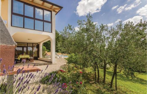 a house with a garden in front of it at Awesome Home In Meloni With Sauna in Karojba