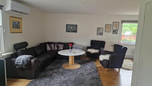 a living room with a couch and two chairs and a table at En stor trea i hus max 4 pers in Nygård