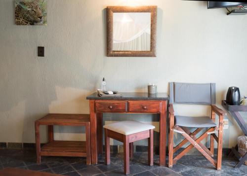 a wooden desk with a chair and a mirror at La Lechere Guest House in Phalaborwa