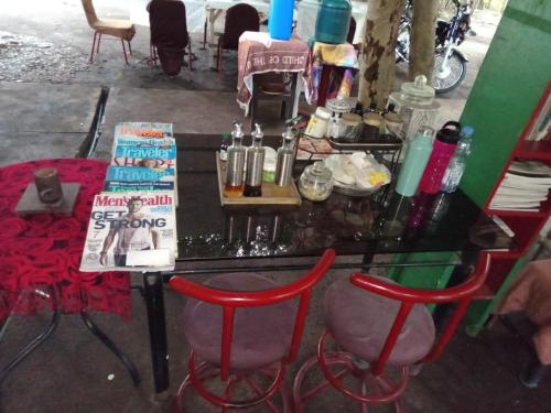 a table with two red chairs and a table with a book at PINOY YOGA POLE PIYOPO LA UNION fan kubo 4 pax in Rimus