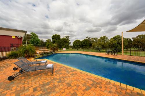 a swimming pool with a bench in front of it at Renmark Country Club in Renmark