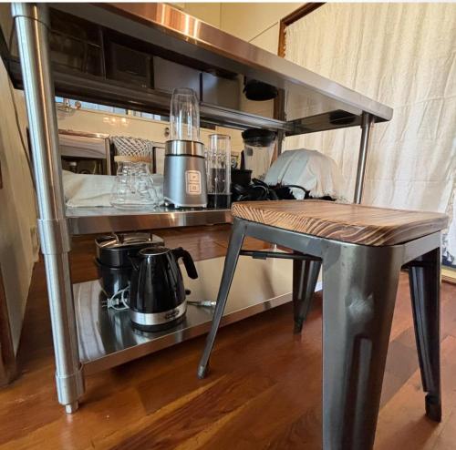 a table and a shelf with a coffee maker on it at 繁華街まで徒歩10分の好立地 観光や食事を楽しむことができます in Amami