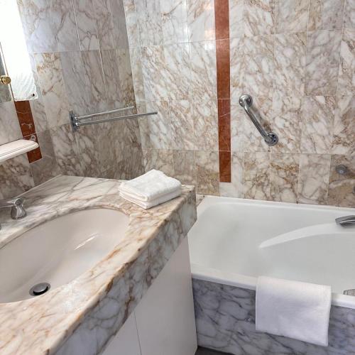 une salle de bain avec une baignoire blanche et un lavabo dans l'établissement 2P Between Croisette Beaches and Antibes Street, à Cannes