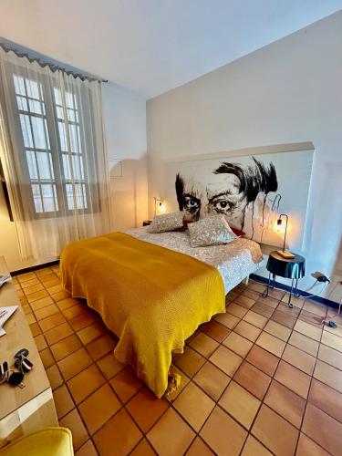 une chambre avec un grand lit avec un tableau au mur dans l'établissement Studio Vernon, à Arles