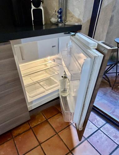 un réfrigérateur vide avec sa porte ouverte dans une cuisine dans l'établissement Studio Vernon, à Arles