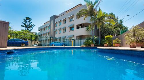 a large blue swimming pool in front of a building at Hampton Court Apartments in Brisbane