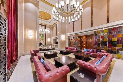 a library with leather chairs and tables and a chandelier at Wyndham Garden Foshan Nanhai in Foshan