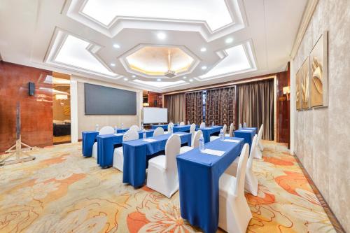 a conference room with blue tables and white chairs at Wyndham Garden Foshan Nanhai in Foshan