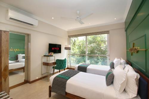 a hotel room with two beds and a window at Theory9 Premium Service Apartments Bandra in Mumbai