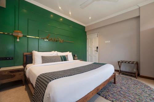 a bedroom with a large bed with a green wall at Theory9 Premium Service Apartments Bandra in Mumbai