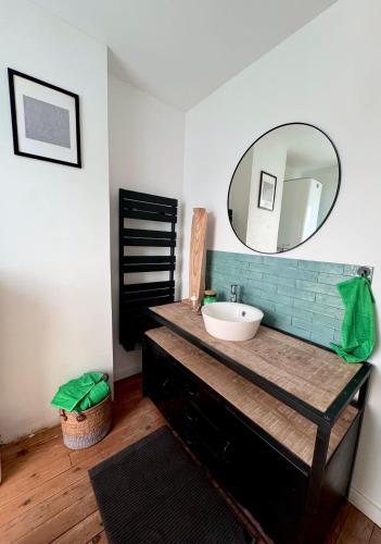 une salle de bain avec un lavabo et un miroir dans l'établissement Maison 3 étages en centre-ville, à Laon