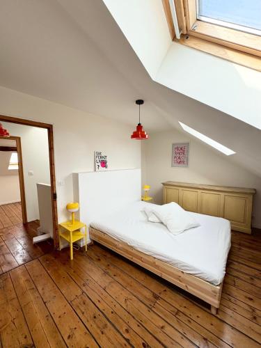 une chambre avec un lit blanc et un parquet dans l'établissement Maison 3 étages en centre-ville, à Laon