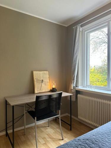 a desk with a chair in a room with a window at Stationsterrassen 15 in Båstad