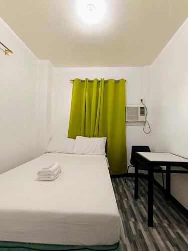 a room with a bed with a green curtain at V Star CALAPAN - HOURLY! DAILY! WEEKLY! MONTHLY! BAGO! MALINIS! MAY PARKING! in Calapan