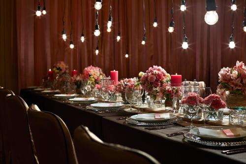 a long table with plates and flowers and candles at Solaire Resort Entertainment City in Manila