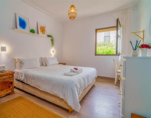 Beach Retreat Taghazout Bay في أغادير: غرفة نوم بيضاء مع سرير ونافذة