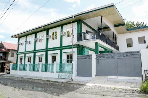 a white and green building with a gate at V Star CALAPAN - HOURLY! DAILY! WEEKLY! MONTHLY! BAGO! MALINIS! MAY PARKING! in Calapan