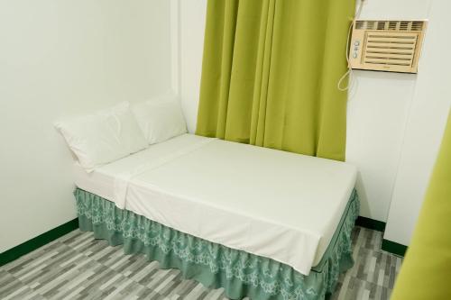 a small bed in a room with a green curtain at V Star CALAPAN - HOURLY! DAILY! WEEKLY! MONTHLY! BAGO! MALINIS! MAY PARKING! in Calapan