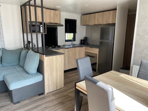 ラウエルウオーフにあるChalet in Holland am Meerのキッチンとテーブルとソファのあるリビングルーム