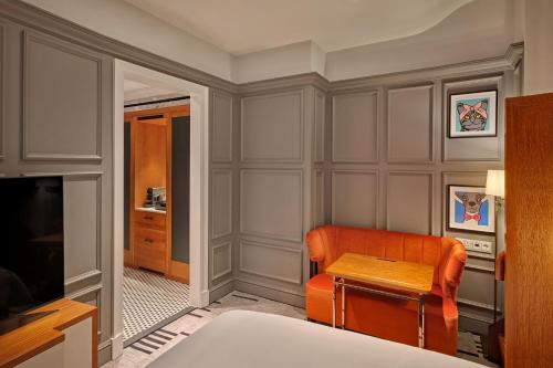 a room with a chair and a table and a television at London Marriott Hotel County Hall in London