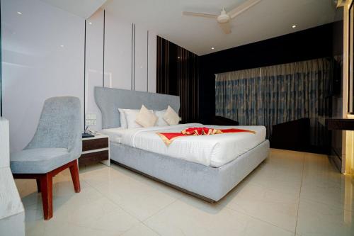 a bedroom with a large bed and a chair at Royal Raj Hotel in Rājshāhi