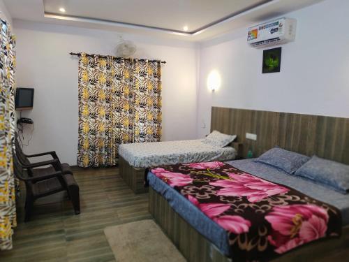 a room with two beds and a chair in it at Spice Garden Farm house in Sultan Bathery