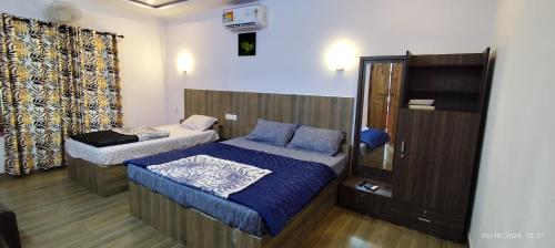 a bedroom with two beds and a cabinet in it at Spice Garden Farm house in Sultan Bathery