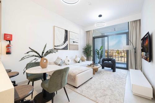 a white living room with a couch and a table at Legacy by Sunrise - Top Amenities and Paddle Court in Dubai