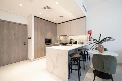 a kitchen with a island with bar stools in it at Legacy by Sunrise - Top Amenities and Paddle Court in Dubai