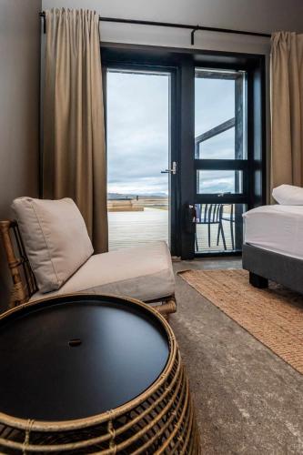a room with a bed and a tub and a window at Stuðlastrengur - Luxury private villa in Selfoss