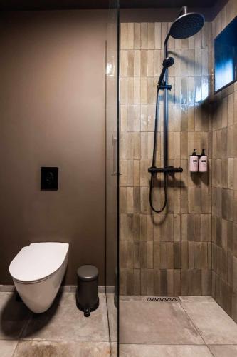 a bathroom with a shower with a toilet and a glass door at Stuðlastrengur - Luxury private villa in Selfoss