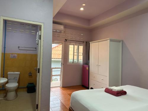 a bedroom with a bed and a bathroom with a toilet at Lanta Garden Home in Ko Lanta