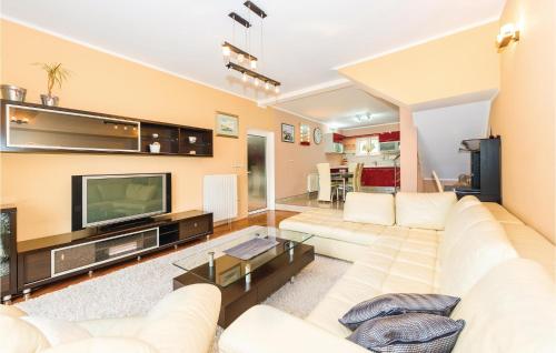 a living room with a white couch and a television at Three-Bedroom Holiday Home In Sibenik in Šibenik